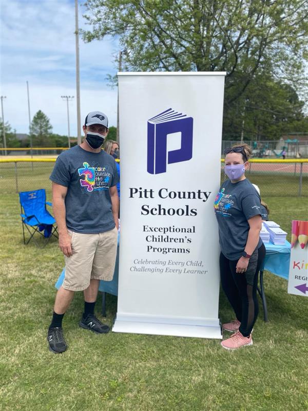 Bailey and Sarah with Pitt County Schools banner at Autastic Extravaganza
